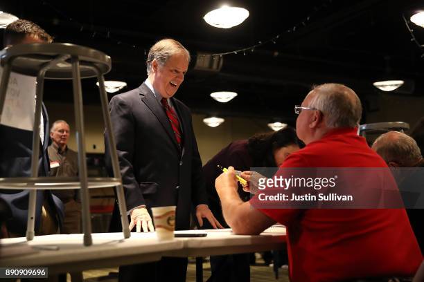 Democratic senatorial candidate Doug Jones checks in to receive his ballot as before voting at Brookwood Baptist Church on December 12, 2017 in...