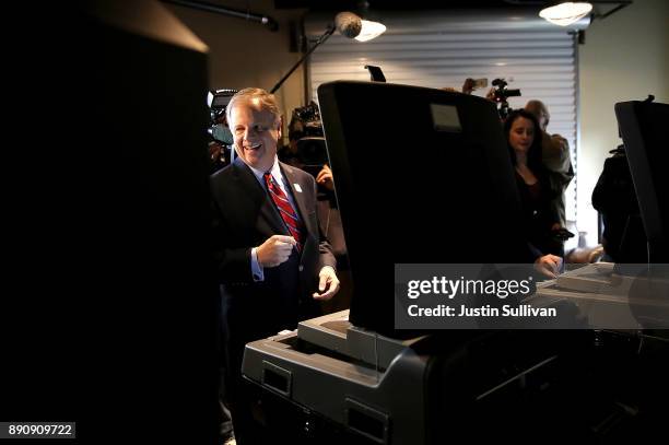 Democratic senatorial candidate Doug Jones casts his ballot as he votes at Brookwood Baptist Church on December 12, 2017 in Mountain Brook, Alabama....