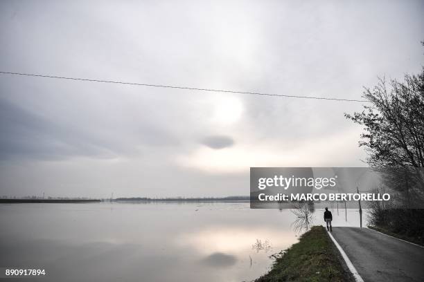 Man looks out onto a flooded area in Brescello on December 12 after the Enza river broke its banks, following heavy rain throughout the northern...