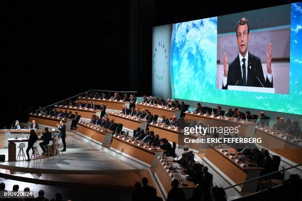 French President Emmanuel Macron is shown on a big screen as he delivers a speech at the One Planet Summit on December 12 at La Seine Musicale venue...