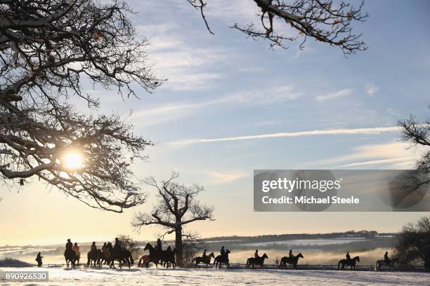 Racehorses head out towards the polytrack gallops in heavy snow at the yard of national hunt trainer Nigel Twiston-Davies on December 12, 2017 in...