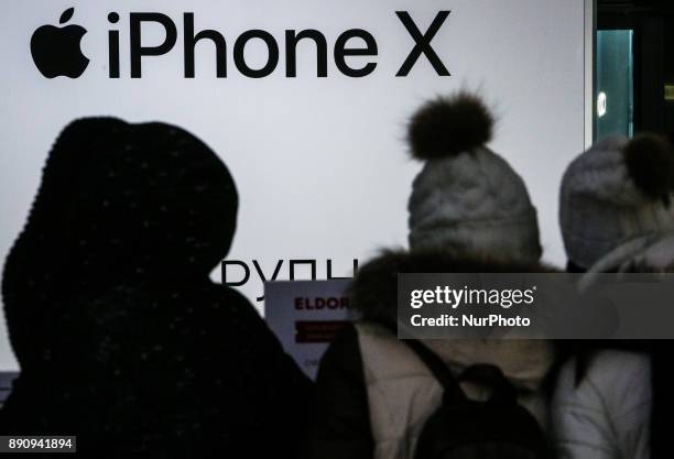 People stay around the Apple promoting table at one of shopping malls in Kyiv, Ukraine, Dec.12, 2017. IPhone X official sales started in Ukraine.