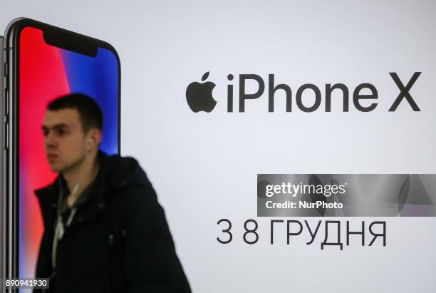 Man walks pastthe Apple promoting placard at one of shopping malls in Kyiv, Ukraine, Dec.12, 2017. IPhone X official sales started in Ukraine.