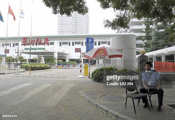 Security guard sits at the main entrance of the Yanxiang Hotel where members of a British student group are quarantined by Chinese authorities over...