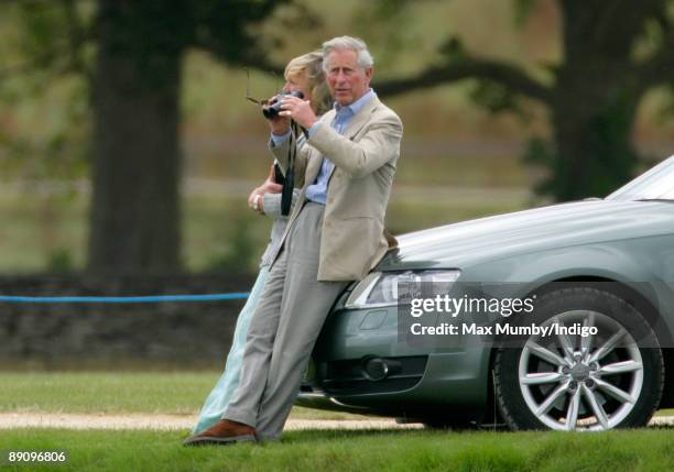 Claire Tomlinson and HRH Prince Charles, Prince of Wales sit on the bonnet of the Prince's Audi Allroad car to watch Prince's William and Harry play...