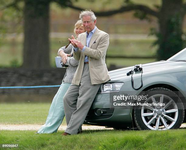 Claire Tomlinson and HRH Prince Charles, Prince of Wales sit on the bonnet of the Prince's Audi Allroad car to watch Prince's William and Harry play...