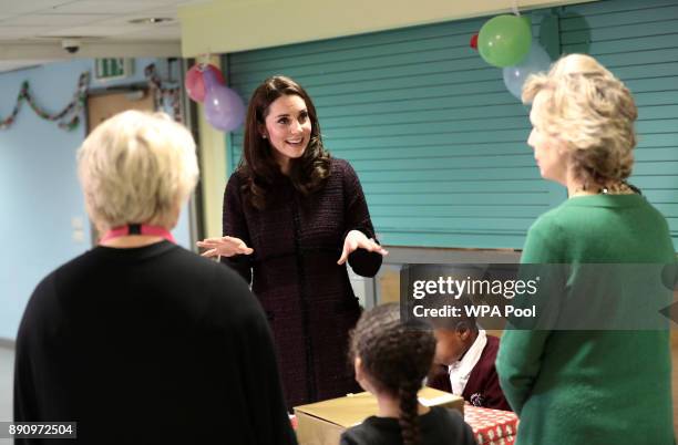 Britain's Catherine, Duchess of Cambridge speaks to children, during a visit to the Rugby Portobello Trust's Christmas party which included children...