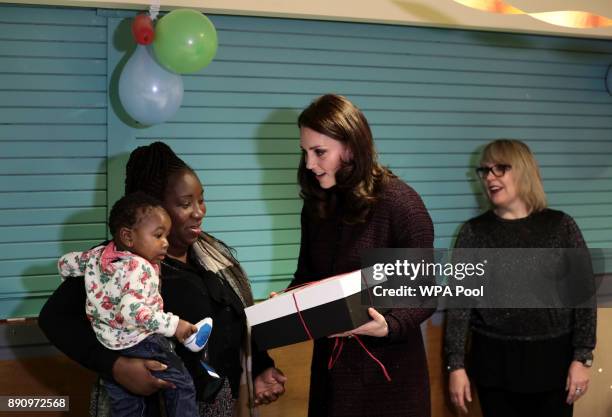 Britain's Catherine, Duchess of Cambridge speaks to children, during a visit to the Rugby Portobello Trust's Christmas party which included children...