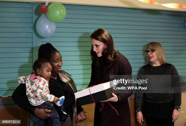 Catherine, Duchess of Cambridge speaks to children, during a visit to the Rugby Portobello Trust's Christmas party which included children affected...