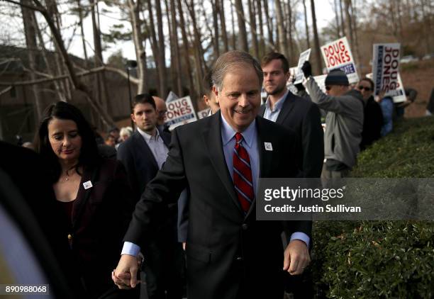 Democratic Senatorial candidate Doug Jones walks with his wife Louise Jones after voting at Brookwood Baptist Church on December 12, 2017 in Mountain...