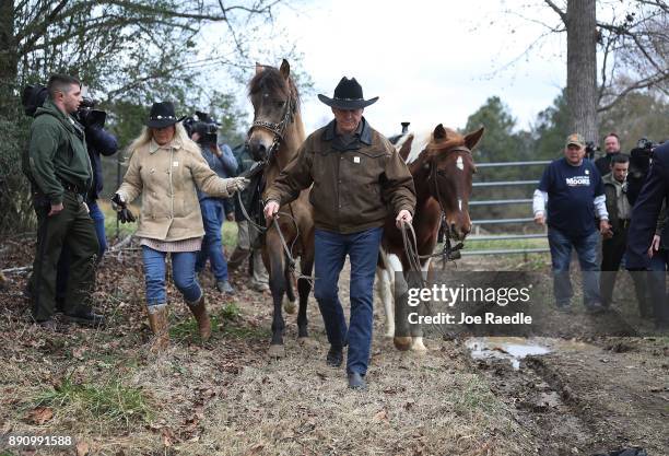 Republican Senatorial candidate Roy Moore and his wife Kayla Moore prepare to ride their horses after casting their votes at the polling location...