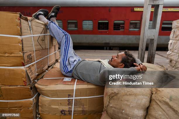 Labourer takes a nap on a cold day at Nizamudin railway station, on December 12, 2017 in New Delhi, India.