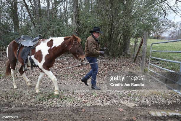 Republican Senatorial candidate Roy Moore prepares to tie up his horse after arriving to cast his vote at the polling location setup in the Fire...