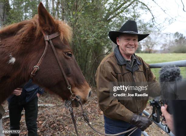 Republican Senatorial candidate Roy Moore prepares to tie up his horse after arriving to cast his vote at the polling location setup in the Fire...