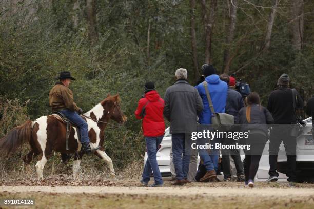 Media members watch as Roy Moore, Republican candidate for U.S. Senate from Alabama, arrives on horseback to a polling location in Gallant, Alabama,...