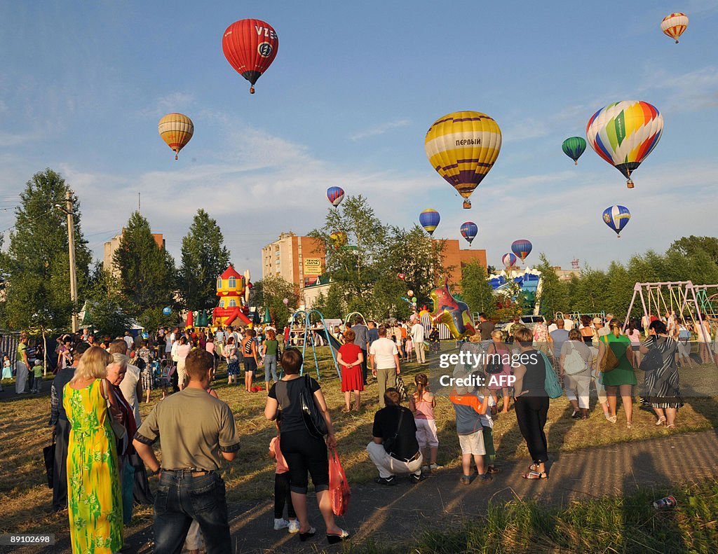 People watch as hot-air balloons rise up