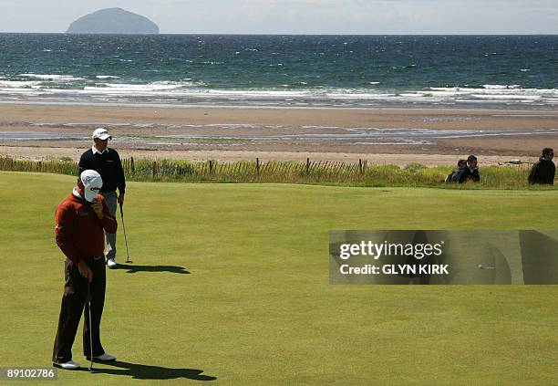 Northern Irish golfer Graeme McDowell reacts as he misses his putt on the 4th green, on the final day of the 138th British Open Championship at...