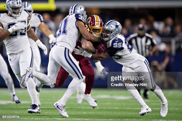 Samaje Perine of the Washington Redskins is tackled by Xavier Woods and Byron Jones of the Dallas Cowboys at AT&T Stadium on November 30, 2017 in...