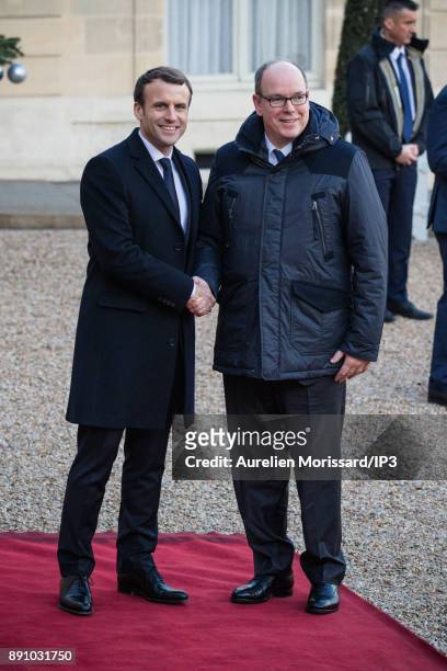 French President Emmanuel Macron greets Prince Albert II of Monaco as he arrives at the Elysee Palace for a lunch as part of the One Planet Summit on...