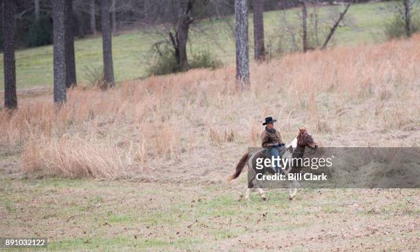 Judge Roy Moore rides his horse across a field on his way to vote at the Gallant Volunteer Fire Department in Gallant, Ala., on Tuesday, Dec. 12,...