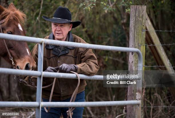 Judge Roy Moore ties his horse to a fence as he arrives to vote at the Gallant Volunteer Fire Department in Gallant, Ala., on Tuesday, Dec. 12, 2017.