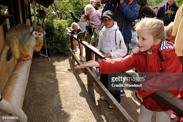 In this handout photo, provided by the Belgian Royal Palace, Princess Elizabeth of Belgium feeds a monkey as she attends a Summer Photocall at...