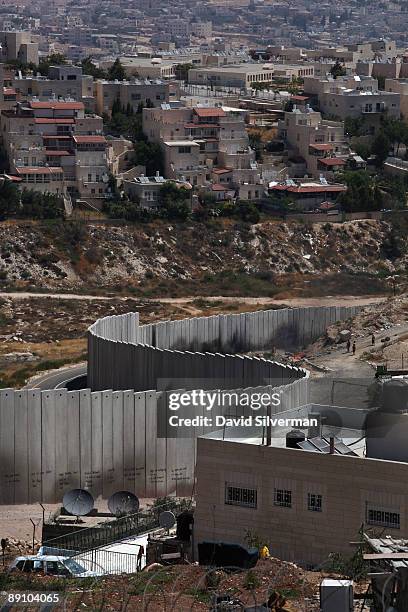 Israel's controversial West Bank barrier weaves its way between the Palestinian refugee camp of Shuafat and the Jewish neighbourhood of Pisgat Zeev...