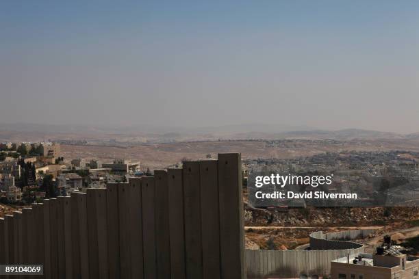 Israel's controversial West Bank barrier weaves its way between the Palestinian refugee camp of Shuafat and the Jewish neighbourhood of Pisgat Zeev...