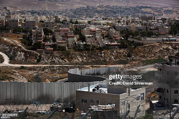 Israel's controversial West Bank barrier weaves its way between the Palestinian refugee camp of Shuafat and the Jewish neighbourhood of Pisgat Zeev...
