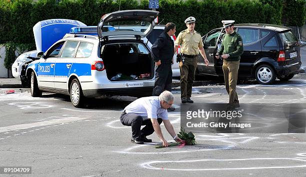 Man lays down flowers at crash site during accident clearance on July 19, 2009 in Menden near Arnsberg, Germany. A car rammed a parade in the German...