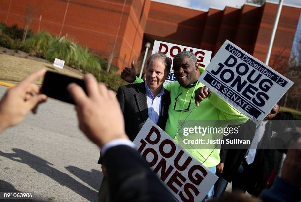 Democratic senatorial candidate Doug Jones takes a picture with voters outside of a polling station at the Bessemer Civic Center on December 12, 2017...