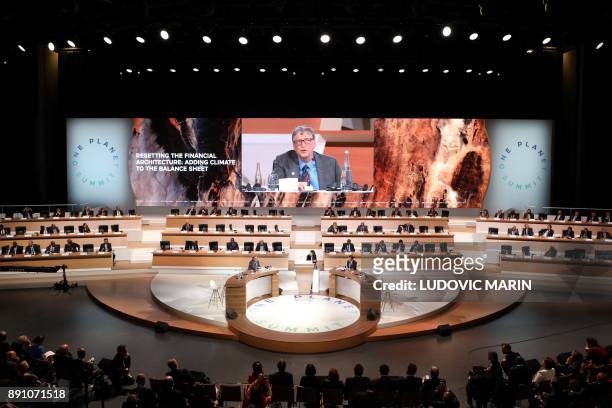 Philanthropist and co-founder of the Microsoft Corporation Bill Gates is shown on a big screen as he delivers a speech at the One Planet Summit on...