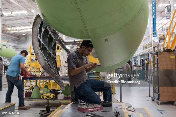 Worker assembles the tail of an aircraft at the Bombardier Inc. Aerospace manufacturing facility in Queretaro, Mexico, on Tuesday, Nov. 7, 2017. With...