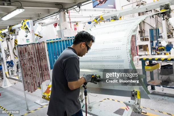 Worker wears protected goggles while assembling the tail of an aircraft at the Bombardier Inc. Aerospace manufacturing facility in Queretaro, Mexico,...