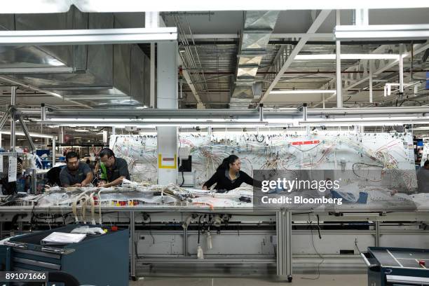 Workers handle electronic components during assembly of harnesses at the Bombardier Inc. Aerospace manufacturing facility in Queretaro, Mexico, on...