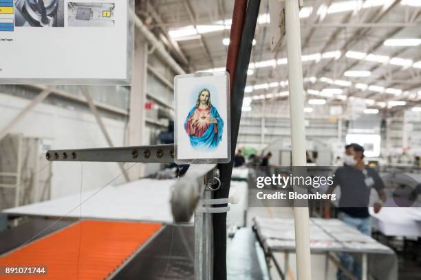 Catholic prayer card is seen at a workstation inside the Tighitco Inc. Manufacturing facility in San Luis Potosi, Mexico, on Thursday, Nov. 16, 2017....