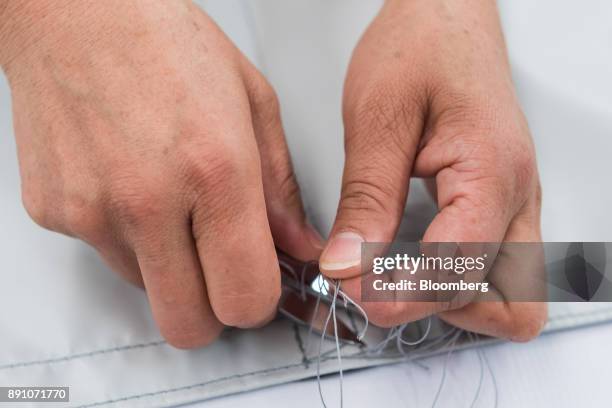 Worker cuts access thread while assembling aircraft cargo nets at the Tighitco Inc. Manufacturing facility in San Luis Potosi, Mexico, on Thursday,...