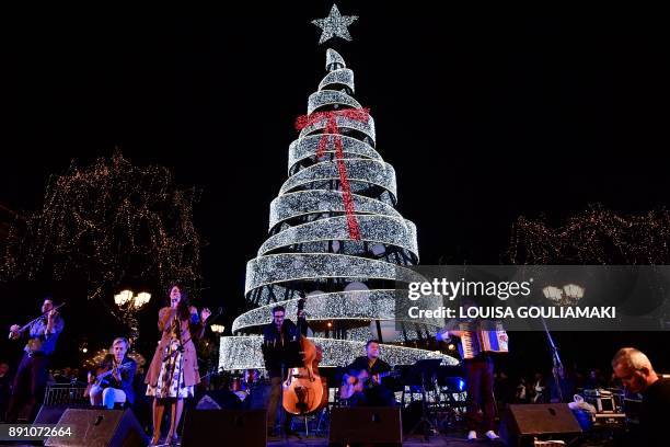 Band performs in front of a lit Christmas tree in central Athens Syntagma square on December 12, 2017 during the inauguration of the Christmas season...