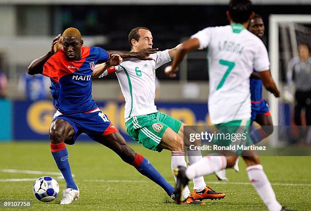 Midfielder James Marcelin of Haiti dribbles the ball past Gerardo Torrado of Mexico during the CONCACAF Gold Cup Quarterfinals at Dallas Cowboys...