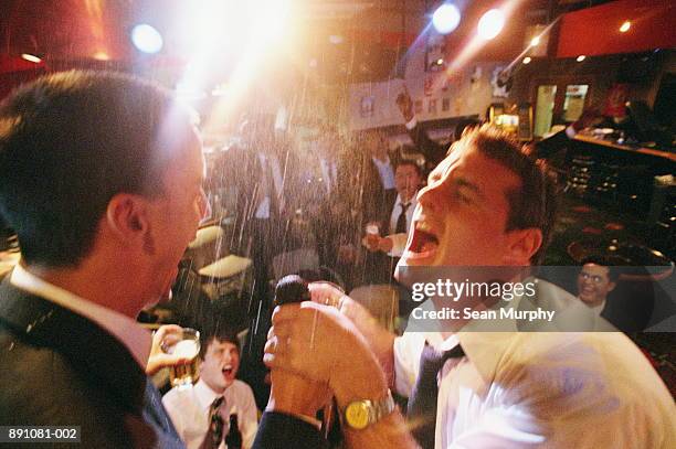 two businessmen singing on stage in nightclub - karaoke stock pictures, royalty-free photos & images
