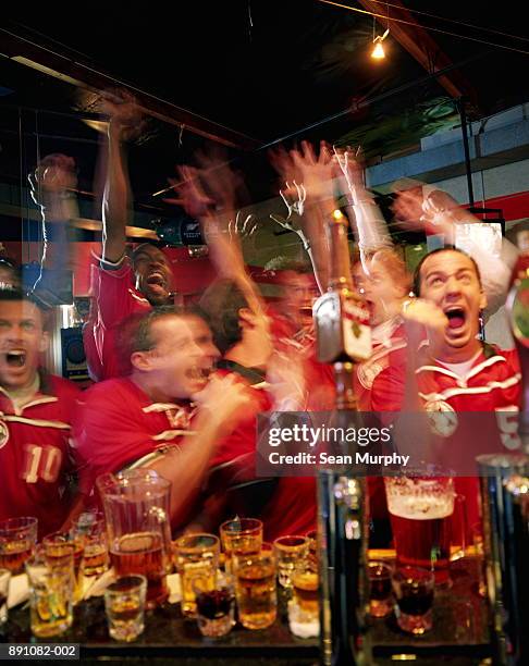 soccer fans cheering in sports bar - multiple exposure sports stock pictures, royalty-free photos & images