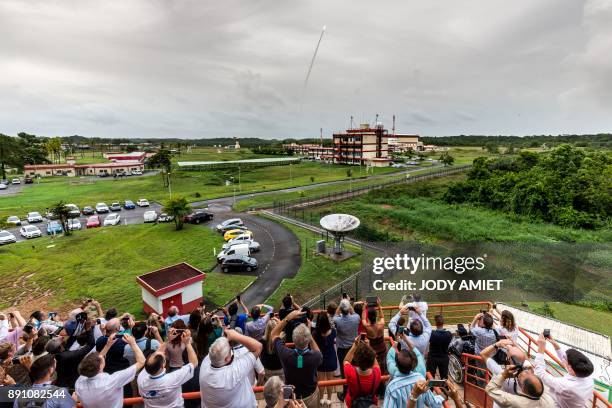 People capture images as an Ariane 5 rocket blasts off from the Kourou Space Centre carrying four Galileo satellites, on December 12 in Kourou,...