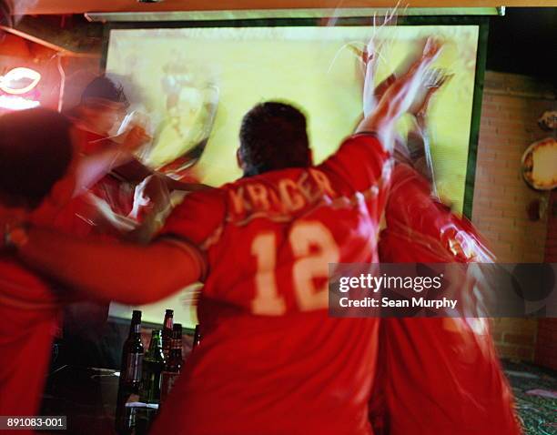 soccer fans watching match in sports bar, rear view (blurred) - watching sport television stock pictures, royalty-free photos & images