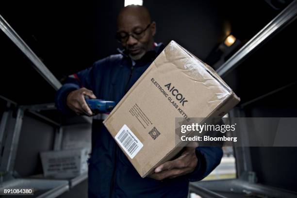 Letter carrier scans a package while preparing a vehicle for deliveries at the United States Postal Service Joseph Curseen Jr. And Thomas Morris Jr....