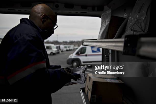 Letter carrier scans a package while preparing a vehicle for deliveries at the United States Postal Service Joseph Curseen Jr. And Thomas Morris Jr....
