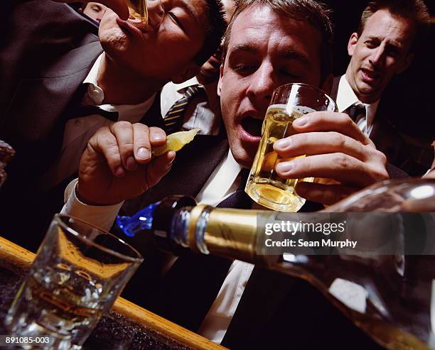 businessmen having drinks at bar, man holding glass and slice of lime - binge drinking stock pictures, royalty-free photos & images