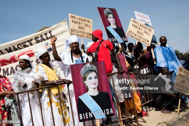 People wait for Queen Letizia of Spain with banners prior to an official lunch with Senegalese First Lady Marieme Faye Sall on December 12, 2017 in...