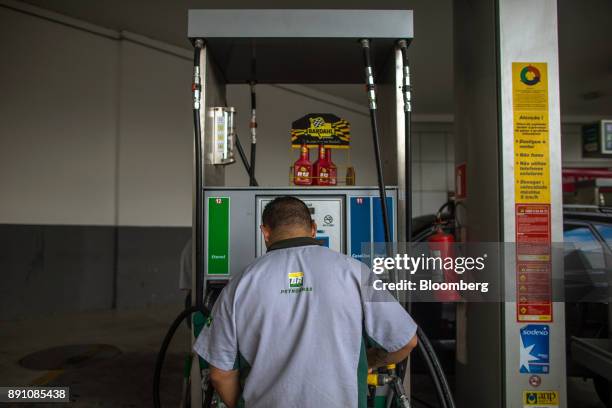An attendant stands in front of a fuel pump at a Petrobras Distribuidora SA gas station in Sao Paulo, Brazil, on Monday, Dec. 11, 2017. Petroleo...