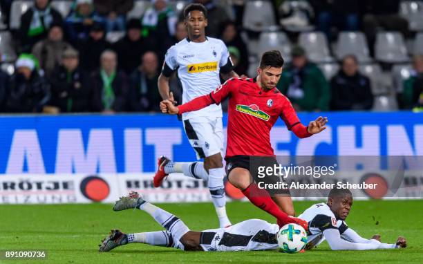 Denis Zakaria of Moenchengladbach challenges Marco Terrazzino of Freiburg during the Bundesliga match between Sport-Club Freiburg and Borussia...
