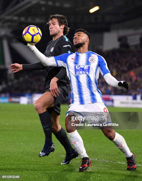 Elias Kachunga of Huddersfield Town handles the ball under pressure from Marcos Alonso of Chelsea during the Premier League match between...
